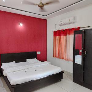 a bedroom with a bed with a red wall at Vasantam Beach Resort in Kashid