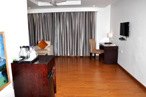 a hotel room with a desk and a room at Triguna Clarks Inn Kurnool in Kurnool