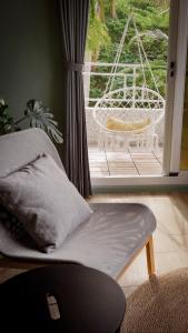 Zimmer mit einem Stuhl und einem Fenster mit einer Schaukel in der Unterkunft 富士A’tolan in Fushan