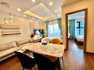 sala de estar con sofá y mesa con sillas en FLC Sea Tower Quy Nhơn - Codotel Cạnh Biển Quy Nhơn, en Quy Nhon