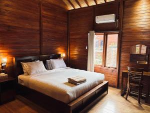 een slaapkamer met een bed met houten wanden en een raam bij Uli Wood Villa, Jimbaran BALI - near GWK in Jimbaran
