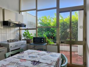 eine Küche mit einem Tisch, einem TV und einem Fenster in der Unterkunft La casa del nonno in Borgagne