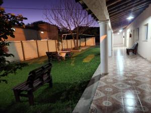 zwei Bänke, die nachts auf dem Rasen im Garten sitzen in der Unterkunft Hotel LasNegritas in San Agustín de Valle Fértil