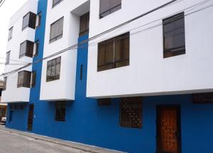 un edificio azul y blanco con puerta en APARTAMENTOS COMPLETOS Cama Queen a 10 min Aeropuerto Lima Per, en Lima