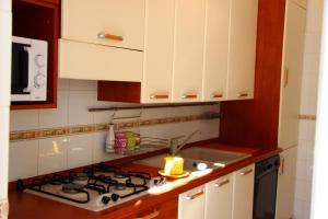 a kitchen with white cabinets and a stove top oven at Tempio del Sole in Rome