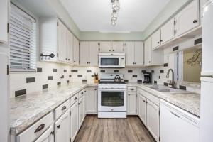 uma cozinha com armários brancos, um lavatório e um micro-ondas em Countryside Family Cottages near Lake Bella Vista em Rockford