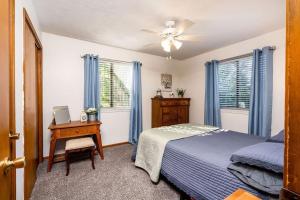 um quarto com uma cama, uma secretária e janelas em Countryside Family Cottages near Lake Bella Vista em Rockford