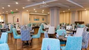 a dining room with blue chairs and tables at Florida Hotel in Nha Trang