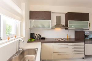 a kitchen with white and brown cabinets and a sink at Rodanthi Villas in Darmarochori