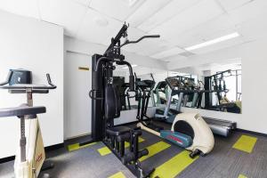 a gym with several tread machines in a room at Comfortable King Bed Studio in Rose Hill with Parking in Sydney