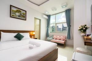 Habitación de hotel con cama y silla en Vivianne Boutique Hotel, en Ho Chi Minh