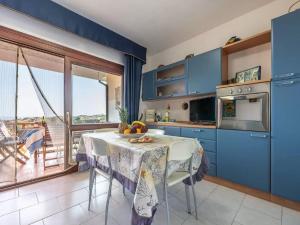 una cocina con armarios azules y una mesa con fruta. en Property in Stintino SS, en Villa Sirena