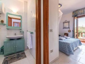 baño con lavabo, cama y espejo en Property in Stintino SS, en Villa Sirena