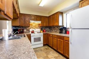eine Küche mit Holzschränken und einem weißen Kühlschrank in der Unterkunft 2 Bella Vista Cottages near Cannonsburg w Parking in Rockford