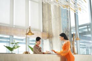 two women standing at a counter in a restaurant at Vertu Harmoni Jakarta in Jakarta +27 photos