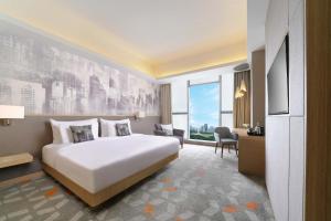 a hotel room with a bed and a desk at Vertu Harmoni Jakarta in Jakarta