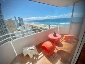 een balkon met een tafel en uitzicht op het strand bij Absolute beachfront main beach Gold Coast in Gold Coast