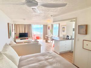 een woonkamer met een bed en een woonkamer met een televisie bij Absolute beachfront main beach Gold Coast in Gold Coast