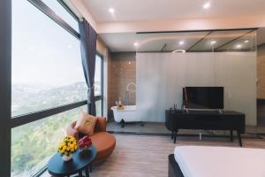 1 dormitorio con cama, bañera y piano en Greenview Hotel DaLat en Dalat
