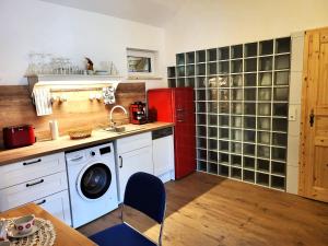 a kitchen with a red refrigerator and a washing machine at Villa Agardy 2 in Balatonkenese