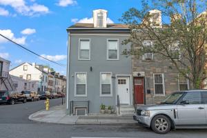 Una casa gris en una calle con un coche aparcado delante. en New Season Royals, Airport West, en Chester