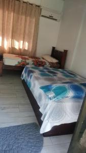 una camera con un letto e un piumone blu e bianco di Casa de Colores a Puntarenas