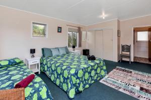เตียงในห้องที่ Sandy Cottage - Tokerau Beach Holiday Home