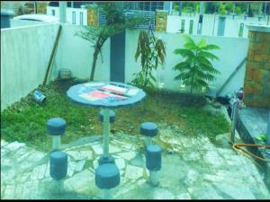ein blauer Tisch in einem Garten mit einem Zaun in der Unterkunft OYO Home 90977 AzZinki Homestay in Cukai