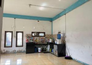 Habitación con cocina y pared con adornos azules. en Steze Guesthouse Syariah Talang Banjar, en Jambi