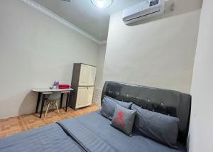 1 dormitorio con cama, mesa y escritorio en Steze Guesthouse Syariah Talang Banjar en Jambi