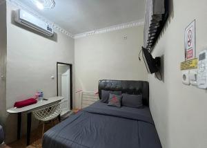 Un dormitorio con una cama y una mesa. en Steze Guesthouse Syariah Talang Banjar, en Jambi