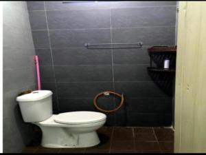 ein Bad mit einem WC und einer rosa Zahnbürste in der Unterkunft OYO Home 90977 AzZinki Homestay in Cukai