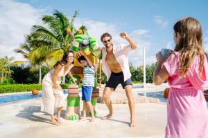 a group of people standing around a pool at a resort at Nickelodeon Hotels & Resorts Punta Cana - Gourmet All Inclusive by Karisma in Punta Cana