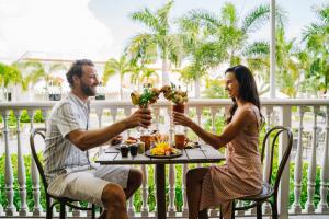 a man and woman sitting at a table with drinks at Nickelodeon Hotels & Resorts Punta Cana - Gourmet All Inclusive by Karisma in Punta Cana