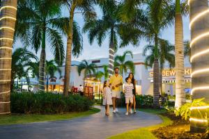 a family walking down a path in front of a resort at Nickelodeon Hotels & Resorts Punta Cana - Gourmet All Inclusive by Karisma in Punta Cana