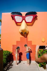 a group of people standing in front of a wall with a giant glasses at Nickelodeon Hotels & Resorts Punta Cana - Gourmet All Inclusive by Karisma in Punta Cana
