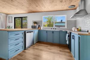 a kitchen with blue cabinets and a wooden ceiling at Recharge in Waurn Ponds in Geelong