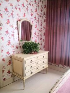 a dresser in a room with a mirror and flowers at Raudtee in Viljandi