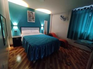 a bedroom with a bed and a blue wall at Hostal El Pilar in Lima