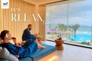 a man and woman sitting on a couch in a hotel room at TTC Van Phong Bay Resort - Himalaya Sauna & Steam Retreat Included in Ninh Hòa