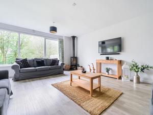 un soggiorno con divano e tavolo di Elm - Woodland Cottages a Bowness-on-Windermere