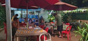 a group of people sitting at a table under an umbrella at Relax Resort Angkor Villa in Siem Reap +40 photos