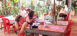 een groep mensen die aan een tafel zitten bij Relax Resort Angkor Villa in Siem Reap