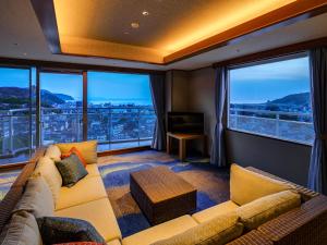 un soggiorno con divano e ampie finestre di Ito Hotel Juraku a Ito