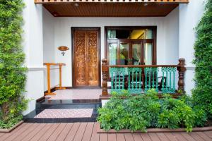 a front door of a house with a balcony at Villa Sirilanna Hotel in Chiang Mai