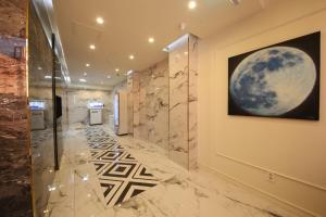 a hallway with a painting of the moon on the wall at Calton Hill Hotel in Jeonju