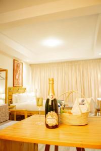 um quarto com uma mesa com uma garrafa de vinho e uma cesta em Thabeng Hotel & Restaurant em Maseru