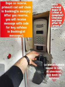 a person holding a pay phone in front of a wall at MAXX Lake Apart in Bacău