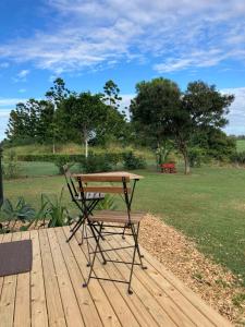 a picnic table on a wooden deck with a field at Sweet Retreat in Bundaberg