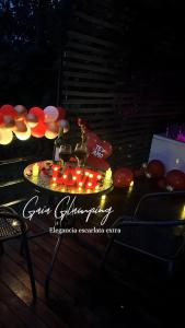 a table with a plate of food with lights on it at Gaia Glamping Elegancia Escarlata estándar 1 in San Rafael